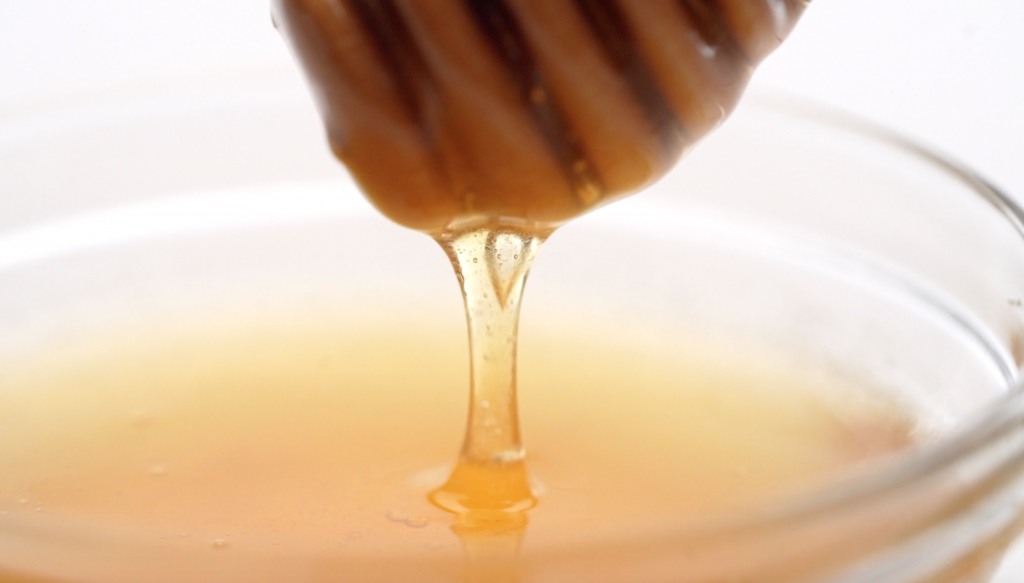 Honey dripping from a honey spoon
