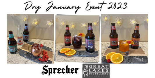 A sprecher mocktail on a cutting board with a bottle of cherry soda, a bottle of orange dream soda, and orange slices