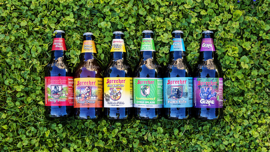 A rainbow of sprecher soda bottles in the grass