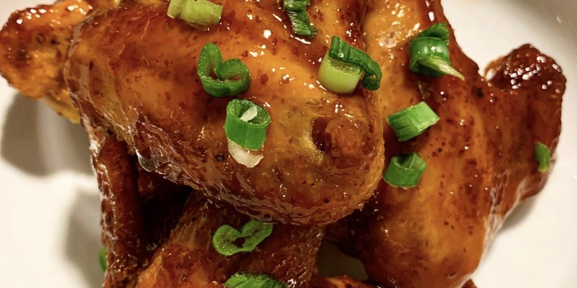 Sprecher Root Beer Glazed Wings with chopped green onions on a plate