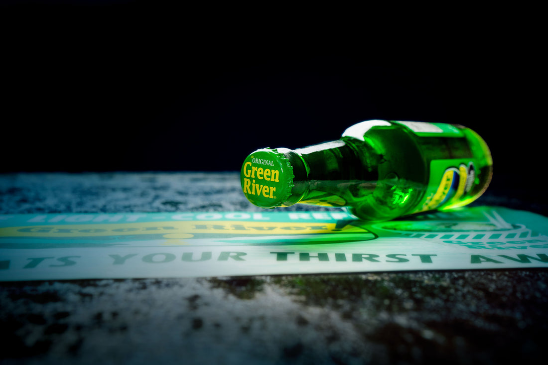 A bottle of Green River Soda on its side with the bottle cap facing forward