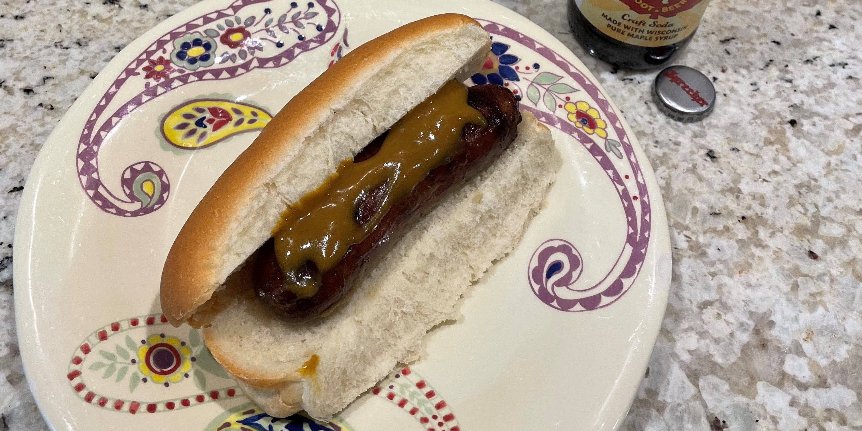 A maple root beer brat on a plate