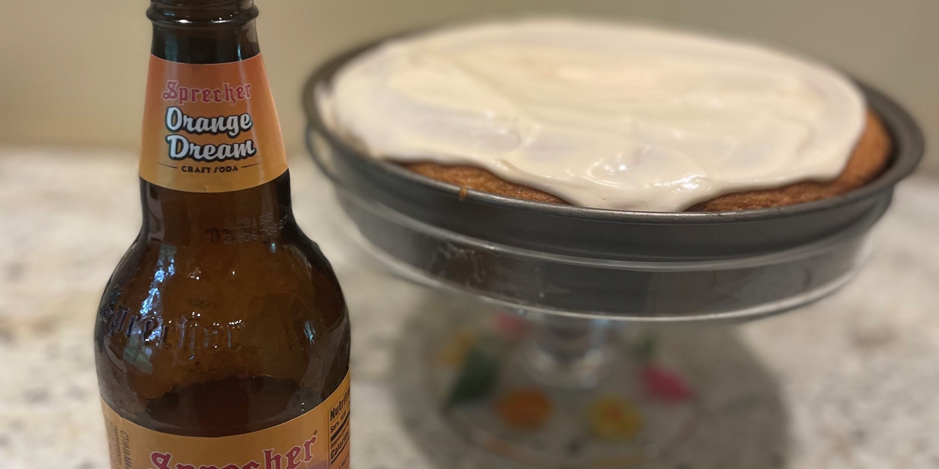 Sprecher Orange Dream Soda next to an Orange Dream Cake
