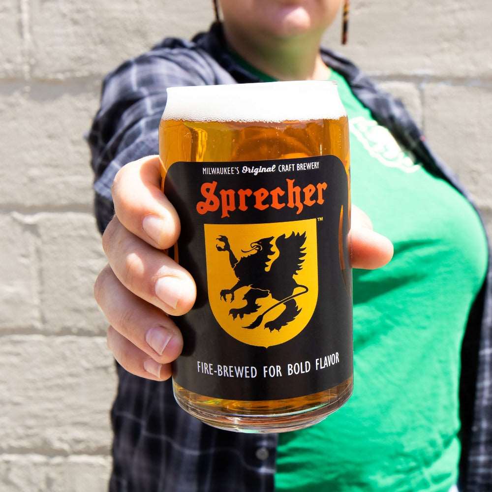 Someone holding out a Sprecher Can Glass full of refreshing fire-brewed craft beer