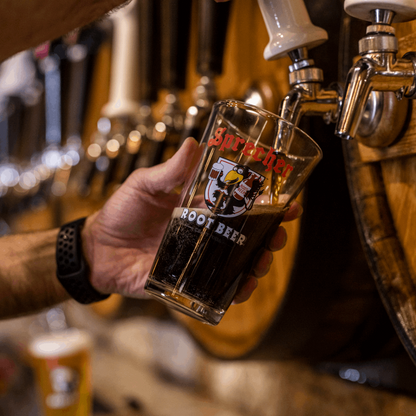 A pint glass being filled with Root Beer using a Sprecher Root Beer Tap Handle