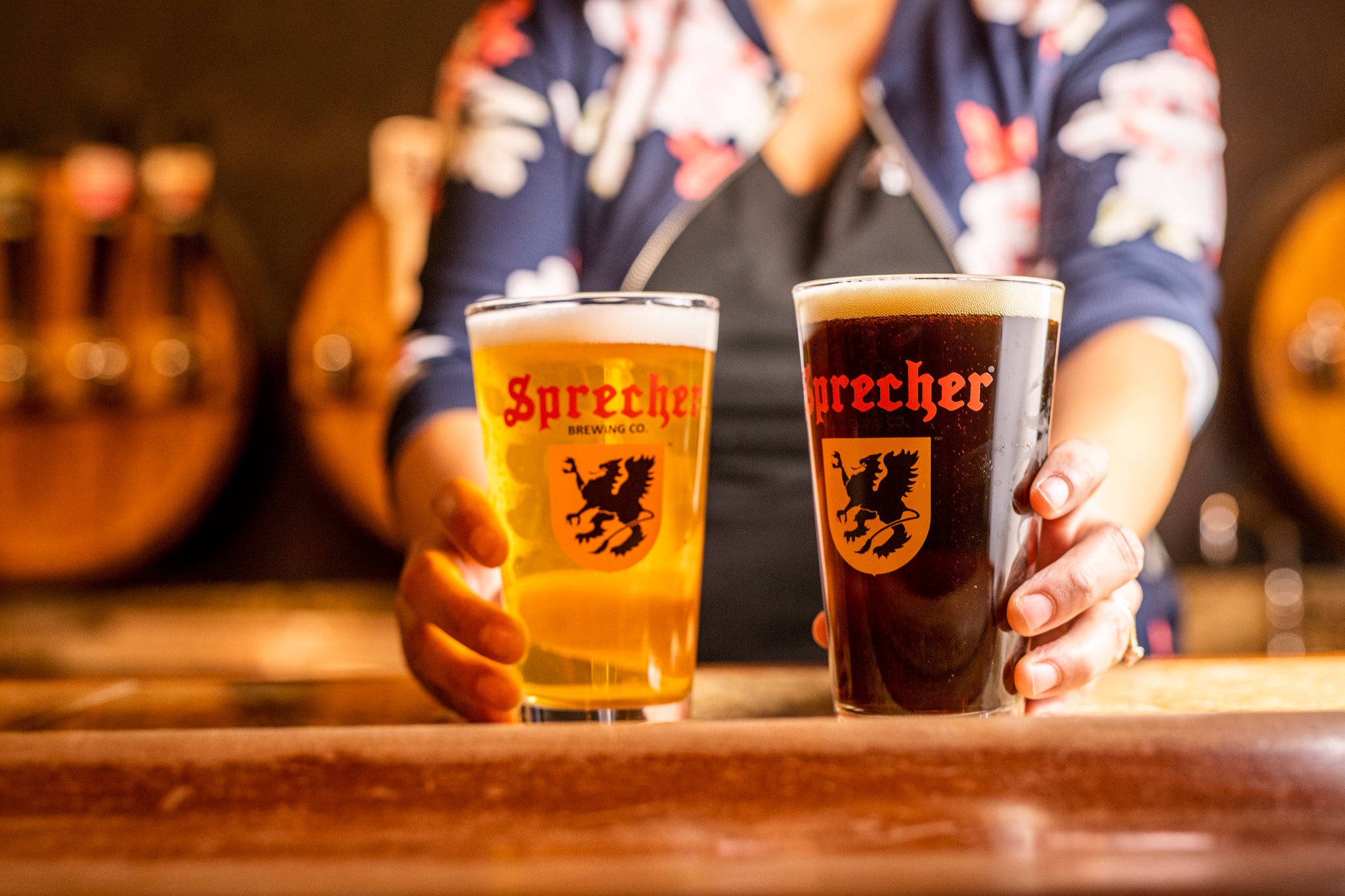 Bartender putting pints of Sprecher Craft Soda and Beer on a bar