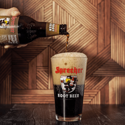 A 16oz bottle of Sprecher Root Beer being poured into a pint glass