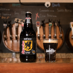 Sparks Root Beer bottle and glass on a bar with beer taps in the background