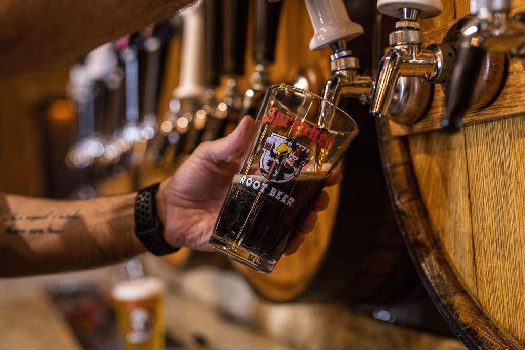 Image of a bartender pouring Sprecher root beer into a pint glass fresh from the keg.