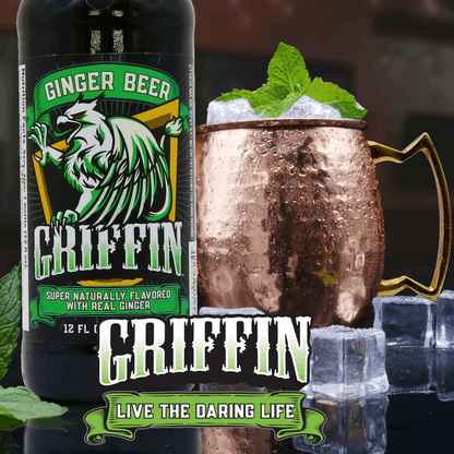A bottle of griffin ginger beer next to a copper mug with ice and mint leaves sticking out.