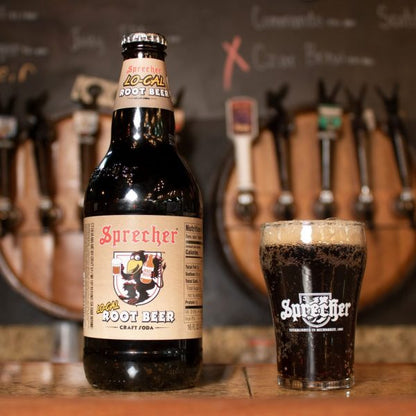 A 16oz bottle of Lo-Cal Root Beer next to a glass of Lo-Cal root beer on the bar.
