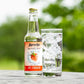 12oz bottle of Sprecher Ripe Strawberry Sparkling water next to a glass of sparkling water outdoors