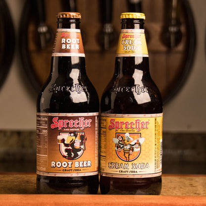 16oz bottles of Sprecher Root Beer and Cream Soda next to each other on a bar